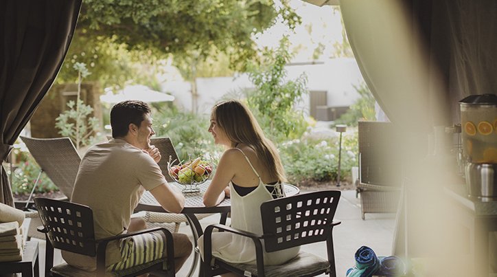 Enjoy a cabana at Glen Ivy Hot Springs. A couple dining outside in their private cabana.